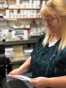 Best Printing Services in Colorado Springs by Third Angle Marilyn checking the quality of recently printed envelopes to deliver quality printing services in Colorado Springs.